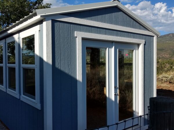 Ranch Style wood shed with french doors, windows, and painted