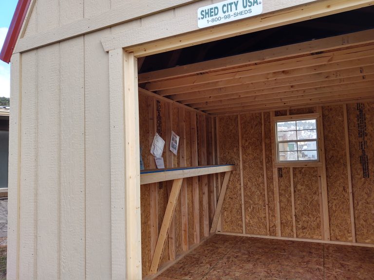 Inside a loft style shed with a wood shelf and a window
